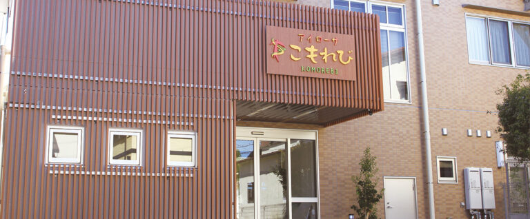 茶色い金属製外壁の施設入口。看板に施設名が表示されている